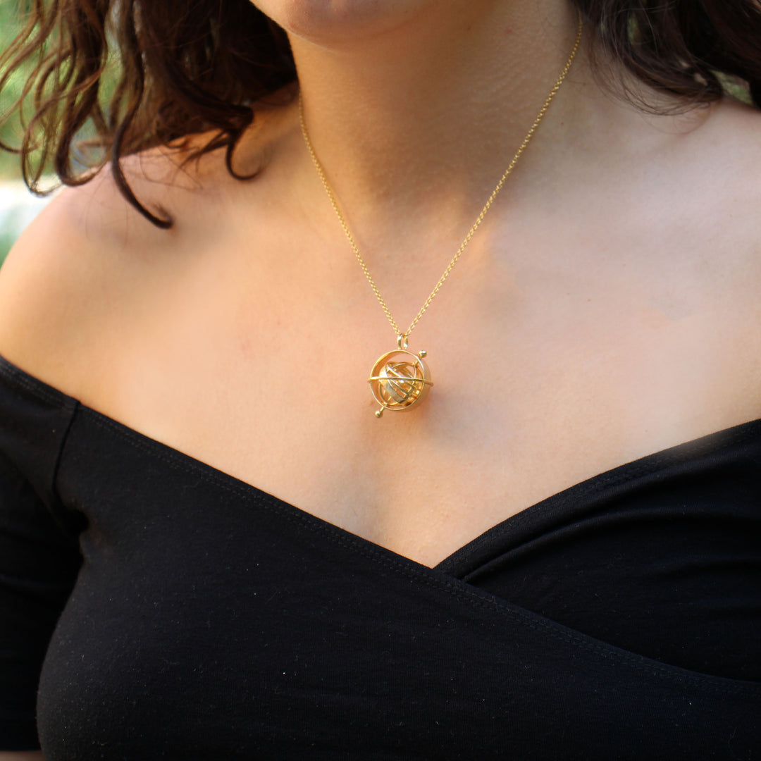 model wearing brass armillary sphere pendant ontogenie