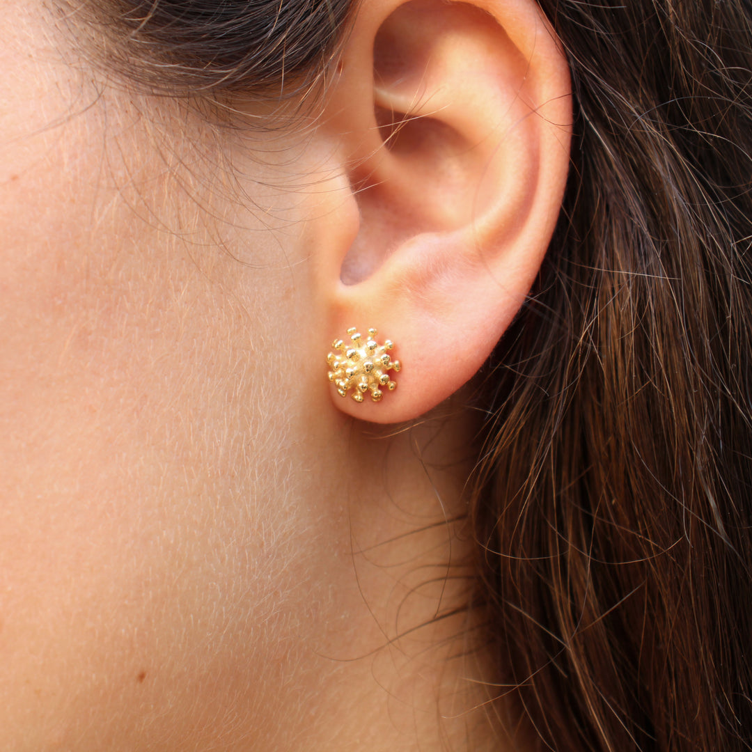 coronavirus stud earrings in gold plated brass on model by Ontogenie